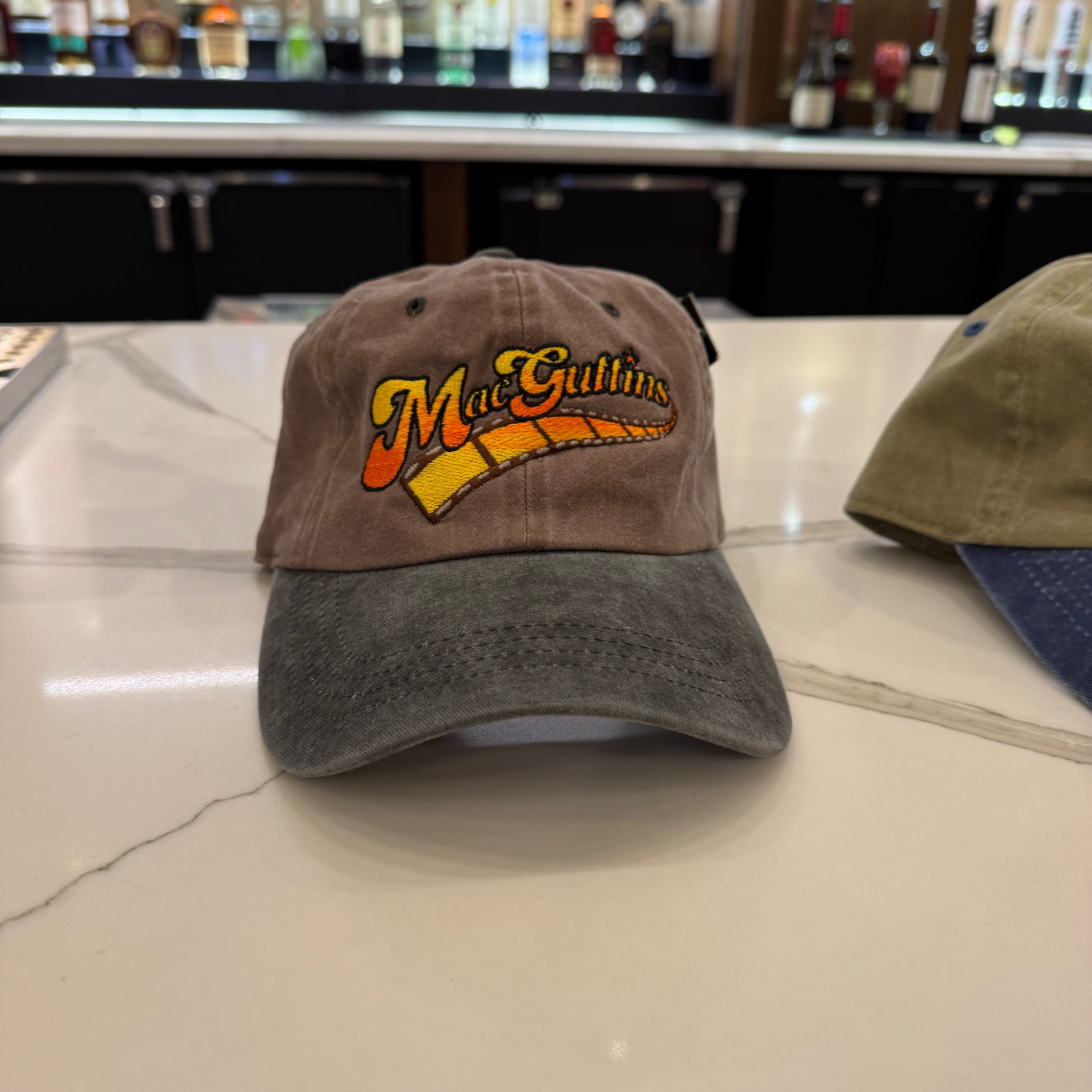 Two baseball caps on a bar counter with a bar in the background