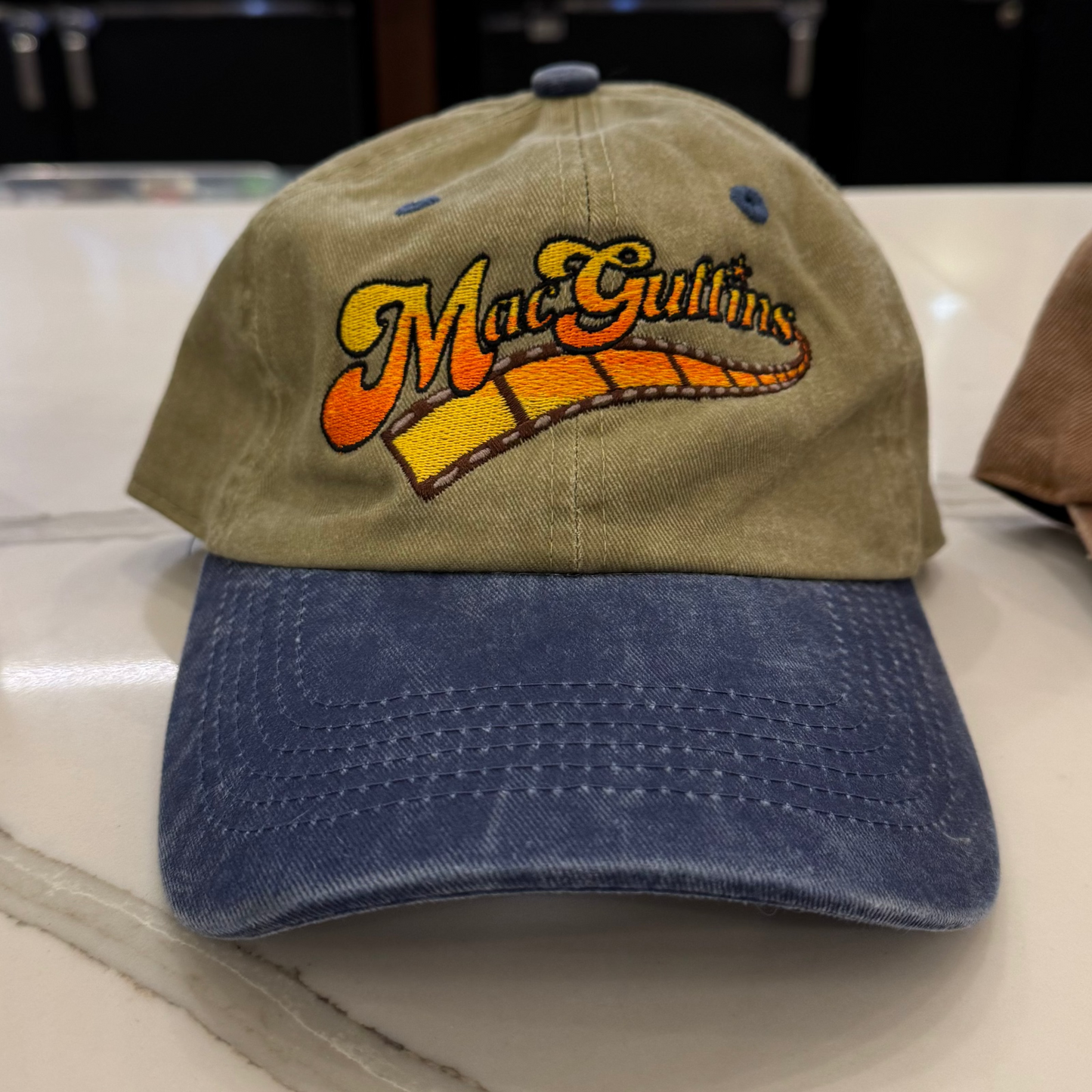 A baseball caps with 'MacGuffins' logo on a bar counter.