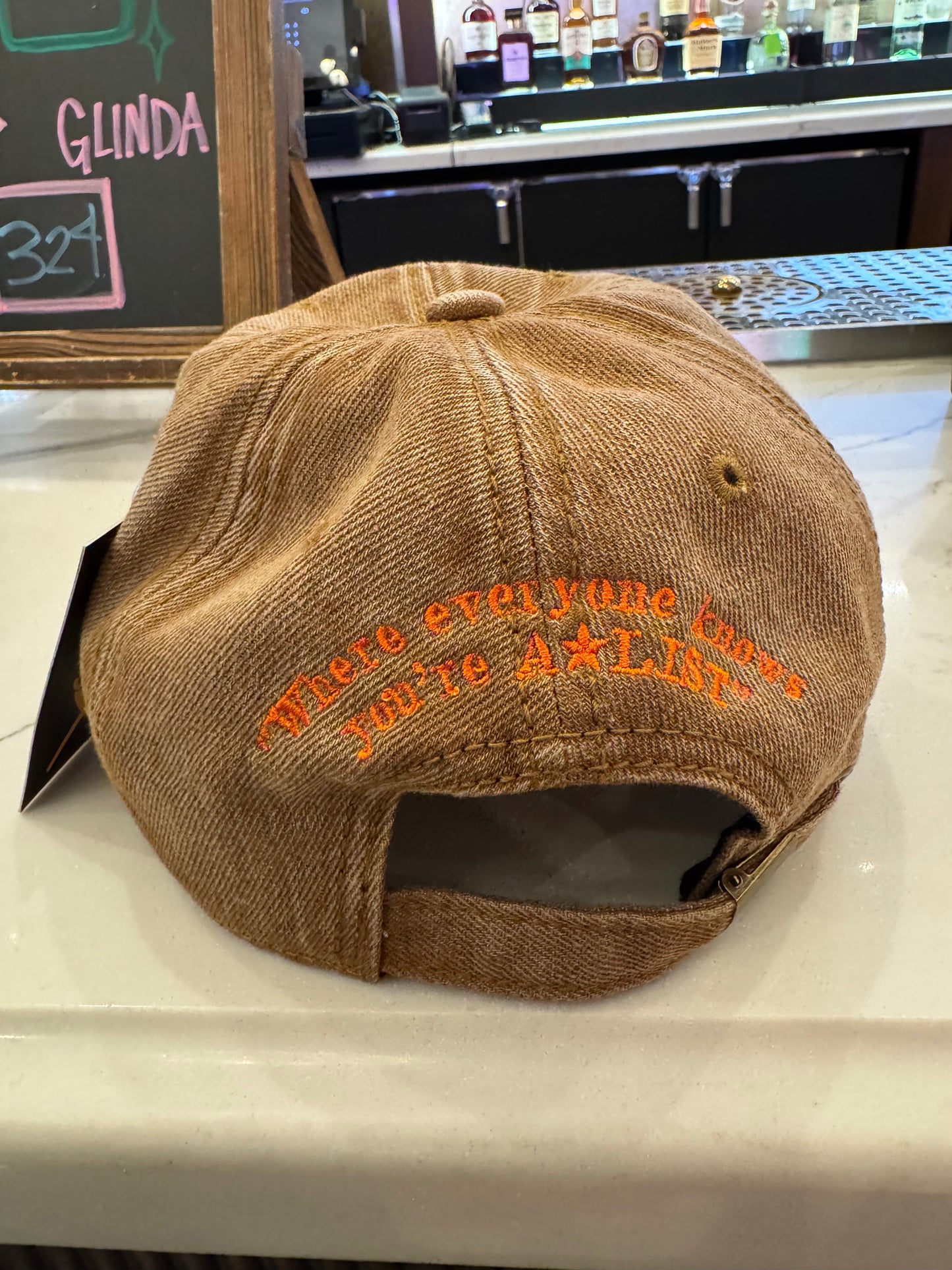 Brown cap with orange text on a counter in a bar setting