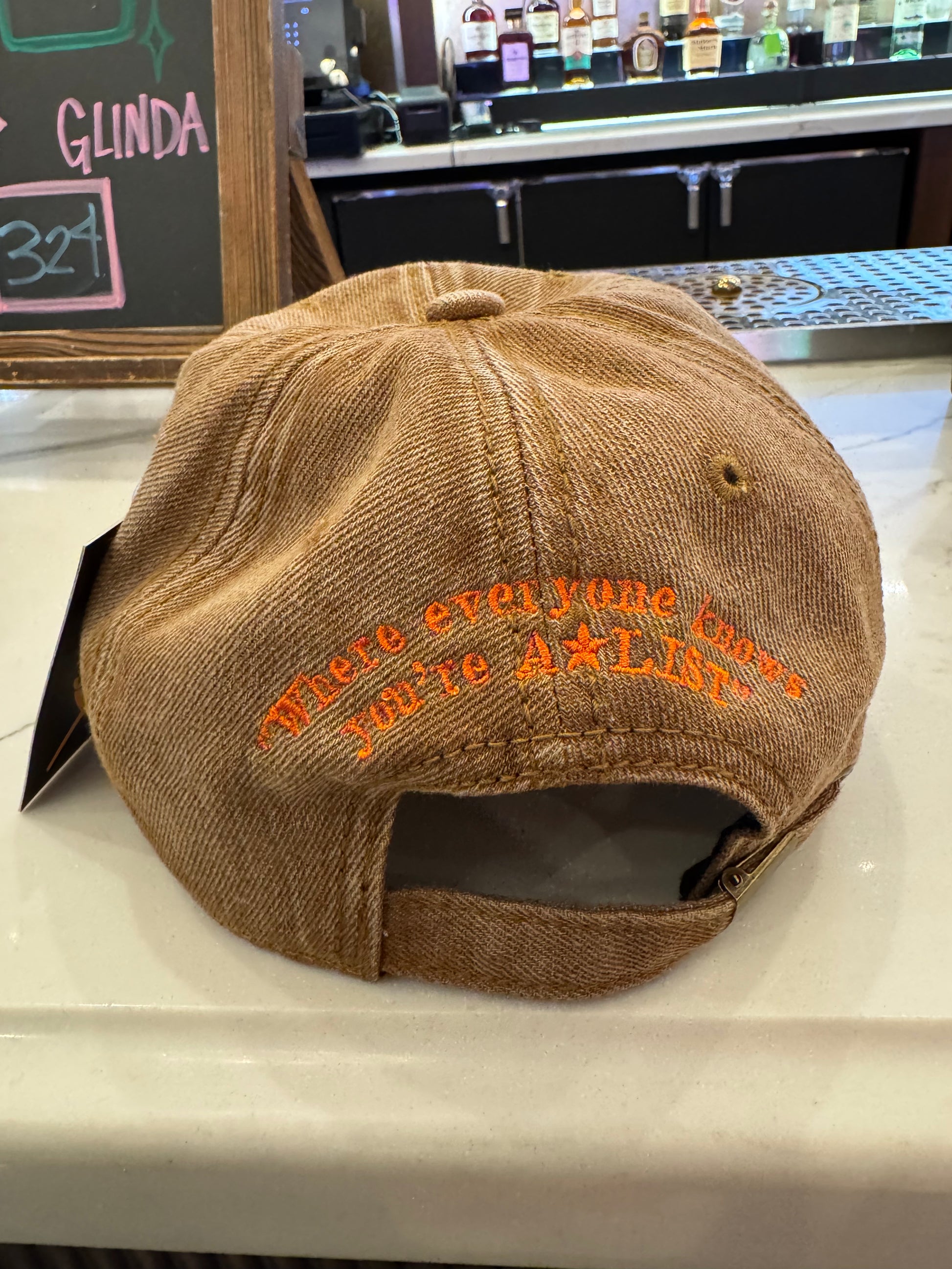 Brown cap with orange text on a counter in a bar setting